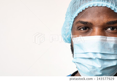 Close up of young african american man surgeon face over white background, empty space Close up of young african american man surgeon face over white background, empty space 143577929