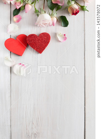 Valentine background with pink rose flowers and handmade wooden hearts, top view on white rustic wood, vertical orientation. Happy lovers day mockup, copy space 143578072