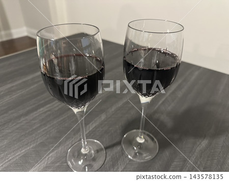 桌上放著兩杯紅酒。 桌上放著兩杯紅酒。 143578135