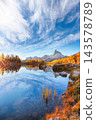 Amazing autumn view of  Lake Federa  at sunrise with majestic rocky mount and colorful trees glowing sunlight in Dolomites 143578789