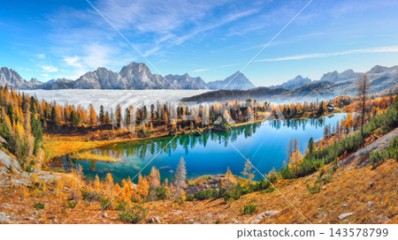 Breathtaking aerial view of crystal clear Lake Federa in Dolomites Alps under sunlight in mist and fog Breathtaking aerial view of crystal clear Lake Federa in Dolomites Alps under sunlight in mist and fog 143578799