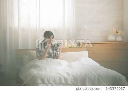 在床上看智能手機的女人 143579037
