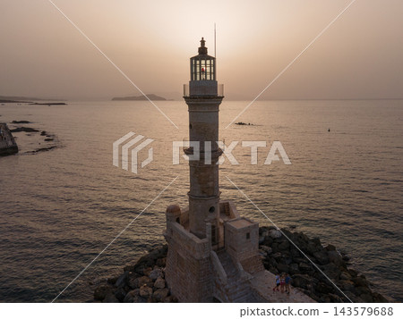 A scenic view of the Old Venetian Harbor in Rethymno, Crete, Greece. This historic port features charming waterfront tavernas, colorful boats, and a majestic lighthouse, reflecting its rich heritage 143579688
