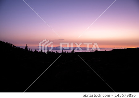 Violet afterglow above the cloud sea on Tenerife. Violet and peach afterglow spreads above the cloud sea seen from the high road in Teide National Park. Stillness and perspective for mindfulness Violet afterglow above the cloud sea on Tenerife. Violet and peach afterglow spreads above the cloud sea seen from the high road in Teide National Park. Stillness and perspective for mindfulness 143579856
