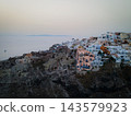 Aerial Drone View of Oia, Santorini. A breathtaking aerial view of the whitewashed village of Oia, Santorini, showcasing luxury resorts with infinity pools overlooking the Aegean Sea. A stunning blend 143579923
