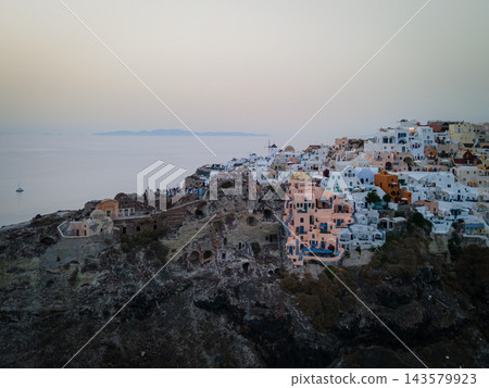 Aerial Drone View of Oia, Santorini. A breathtaking aerial view of the whitewashed village of Oia, Santorini, showcasing luxury resorts with infinity pools overlooking the Aegean Sea. A stunning blend Aerial Drone View of Oia, Santorini. A breathtaking aerial view of the whitewashed village of Oia, Santorini, showcasing luxury resorts with infinity pools overlooking the Aegean Sea. A stunning blend 143579923