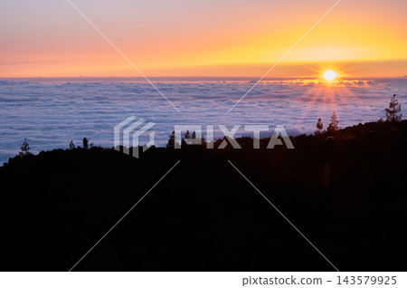 Sun sinks toward the cloud line above the Atlantic. The sun sinks toward the cloud line above the Atlantic with two watchers small on the ridge. Shared sunsets for travel wellbeing and connection camp Sun sinks toward the cloud line above the Atlantic. The sun sinks toward the cloud line above the Atlantic with two watchers small on the ridge. Shared sunsets for travel wellbeing and connection camp 143579925