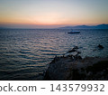 Aerial Sunset View of Mykonos Old Town and Port. A stunning aerial sunset view of Mykonos Old Town, featuring its iconic whitewashed houses, historic windmills, and vibrant port.  143579932