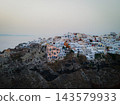 Aerial Drone View of Oia, Santorini. A breathtaking aerial view of the whitewashed village of Oia, Santorini, showcasing luxury resorts with infinity pools overlooking the Aegean Sea. A stunning blend 143579933