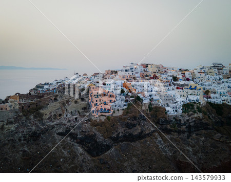 Aerial Drone View of Oia, Santorini. A breathtaking aerial view of the whitewashed village of Oia, Santorini, showcasing luxury resorts with infinity pools overlooking the Aegean Sea. A stunning blend Aerial Drone View of Oia, Santorini. A breathtaking aerial view of the whitewashed village of Oia, Santorini, showcasing luxury resorts with infinity pools overlooking the Aegean Sea. A stunning blend 143579933