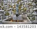 京都鞍馬寺內，一尊觀音像矗立在流水和長滿青苔的石牆之間。 143581203