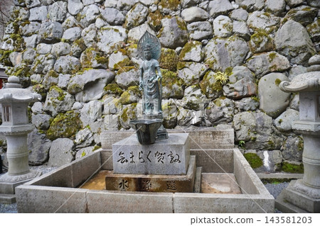 京都鞍馬寺內，一尊觀音像矗立在流水和長滿青苔的石牆之間。 143581203