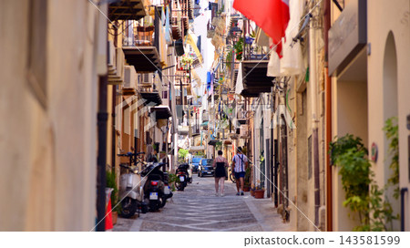 Cefalu, Italy. 21 August 2026. Buildings facade with balconies. Street at centre of old town. A view of typical Italian architecture. This an attractive destination in Sicily. Cefalu, Italy. 21 August 2026. Buildings facade with balconies. Street at centre of old town. A view of typical Italian architecture. This an attractive destination in Sicily. 143581599