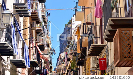Cefalu, Italy. 21 August 2026. Buildings facade with balconies. Street at centre of old town. A view of typical Italian architecture. This an attractive destination in Sicily. Cefalu, Italy. 21 August 2026. Buildings facade with balconies. Street at centre of old town. A view of typical Italian architecture. This an attractive destination in Sicily. 143581600