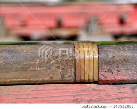 Rail joint pad electrically isolates rails and is secured in place with red clamp for proper operation 143582092
