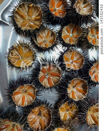 Fresh sea urchins cut open and ready to eat as a seafood delicacy Fresh sea urchins cut open and ready to eat as a seafood delicacy 143582450