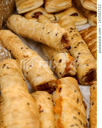 Fresh rolini shaped as filled tubes arranged on a bakery display, highlighting sweet baked pastries with visible filling prepared for customers Fresh rolini shaped as filled tubes arranged on a bakery display, highlighting sweet baked pastries with visible filling prepared for customers 143582522