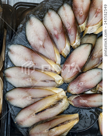 Dry aged mackerel sliced into layers and beautifully arranged on a seafood display at a traditional fish market Dry aged mackerel sliced into layers and beautifully arranged on a seafood display at a traditional fish market 143582549