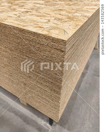OSB, Oriented Strand Board, construction board for floor support kept in industrial warehouse 143582569