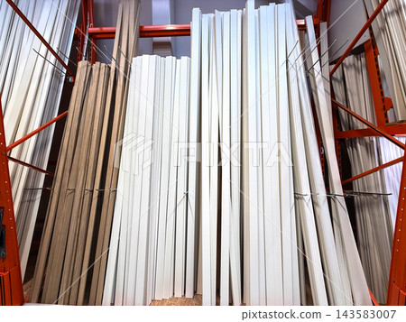 Wooden boards and white trim displayed in hardware store. Wooden boards and white trim displayed in hardware store. 143583007