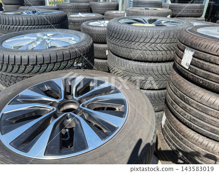 Stack of used vehicle tires and alloy wheels Stack of used vehicle tires and alloy wheels 143583019