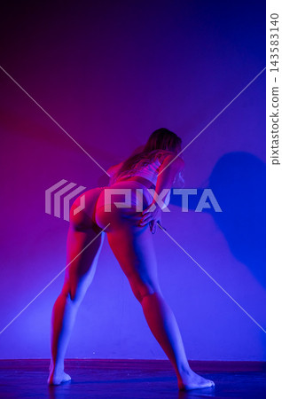 Young woman twerking in neon light. 143583140