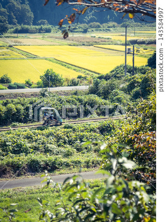 一輛火車行駛在原日本國鐵倉吉線上的鄉村景色中。 一輛火車行駛在原日本國鐵倉吉線上的鄉村景色中。 143584997