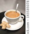 Hot chocolate or coffee or cocoa in a white cup with gingerbread on a black background 143585078