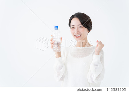 A woman holding a water bottle makes a victory pose. A woman holding a water bottle makes a victory pose. 143585205
