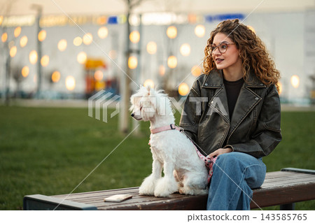 Woman and white poodle enjoying urban park outdoors 143585765
