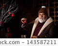 Elegant Santa holding red Christmas ornament at bar 143587211
