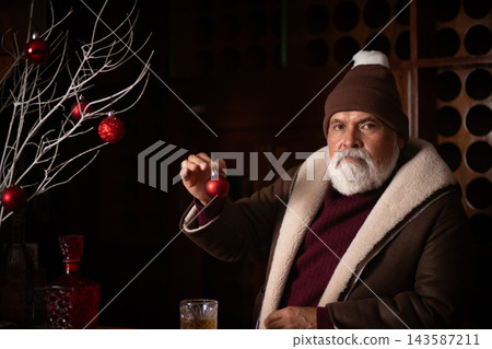 Elegant Santa holding red Christmas ornament at bar Elegant Santa holding red Christmas ornament at bar 143587211