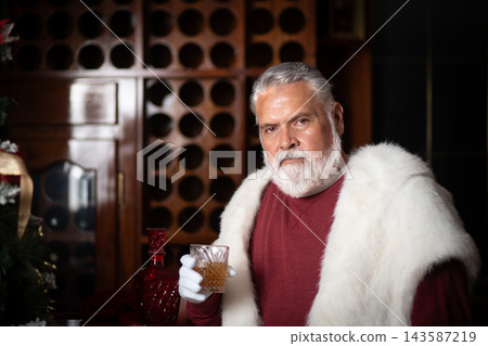 Elegant Santa posing behind bar with holiday drinks Elegant Santa posing behind bar with holiday drinks 143587219