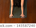 Woman practicing child's pose on yoga mat 143587240