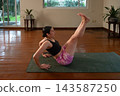 Woman doing boat pose yoga at home 143587250