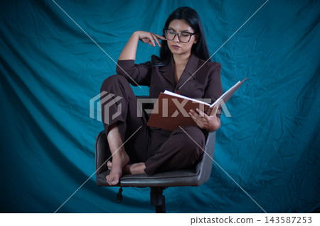Woman reading a book, concentrating, studying, learning, focusing Woman reading a book, concentrating, studying, learning, focusing 143587253