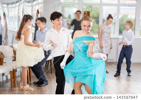 Smiling teenage girl in elegant dress dancing at school prom Smiling teenage girl in elegant dress dancing at school prom 143587847