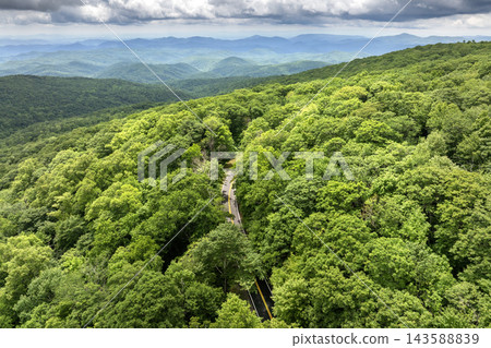 Road trip travel in Appalachian mountains. Car driving on parkway through woods nature in summer wet rainy season. Colorful forest in Tennessee 143588839