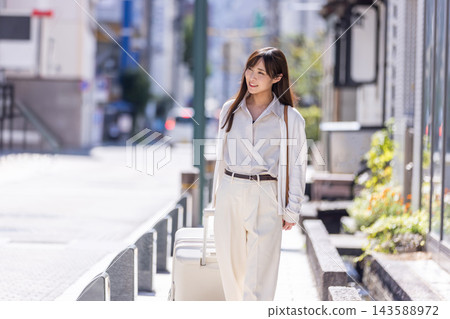 一個年輕女子走在城市裡 一個年輕女子走在城市裡 143588972