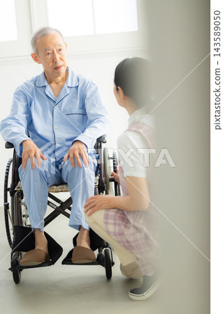 一名男子騎著輪椅和一名女子照顧 一名男子騎著輪椅和一名女子照顧 143589050