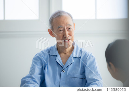 一名男子騎著輪椅和一名女子照顧 一名男子騎著輪椅和一名女子照顧 143589053