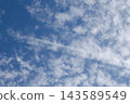 The shadow of a contrail is falling on cirrocumulus clouds. 143589549