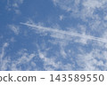 The shadow of a contrail is falling on cirrocumulus clouds. 143589550