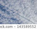 The shadow of a contrail is falling on cirrocumulus clouds. 143589552