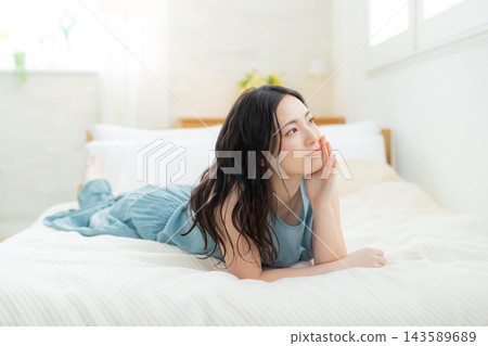 A woman relaxing in bed A woman relaxing in bed 143589689