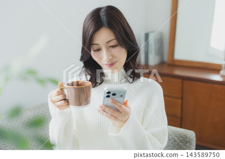 中年婦女在客廳喝咖啡 中年婦女在客廳喝咖啡 143589750