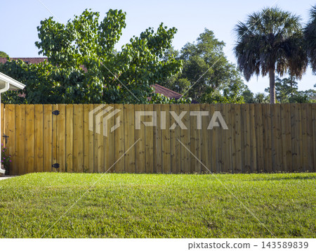 Wooden plank fence in Florida backyard. Timber fencing for grounds protection and privacy. 143589839