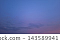 A smooth blue sky fades into soft purple and pink clouds at twilight 143589941