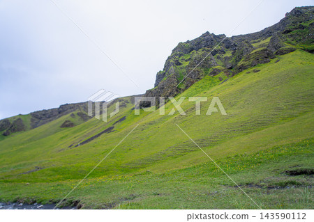 Green hillside and rocky mountain near Vik, Iceland Green hillside and rocky mountain near Vik, Iceland 143590112