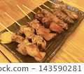 A platter of charcoal-grilled chicken skewers and other grilled meats, perfectly cooked to a fragrant crisp. 143590281